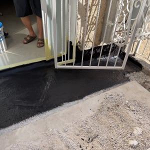 איטום רצפה ליד דלת עם חומר שחור ודלי
