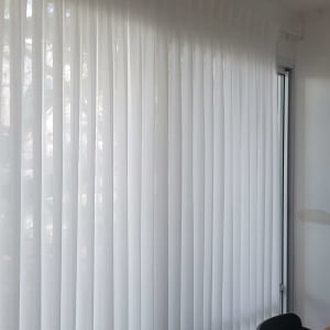 וילון לבן תלוי על חלון גדול