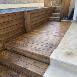 דק עץ עם מדרגות ליד בריכה קטנה