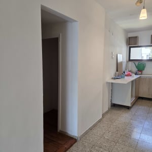 מטבח נקי עם רצפה מבריקה וחפצים מסודרים על השיש