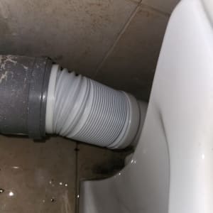 צינור פלסטיק מחובר לאסלה על רצפה רטובה