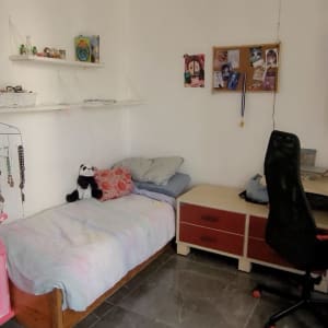 חדר שינה עם מיטה, שולחן עבודה ומדפים מאורגנים