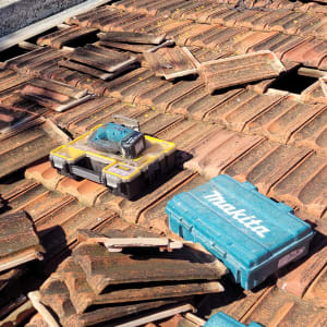 אריחי גג שבורים עם כלי עבודה על הגג