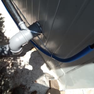 צינור מים דולף מחובר לקיר חיצוני