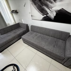 שני ספות אפורות עם ציוד ניקוי על הרצפה