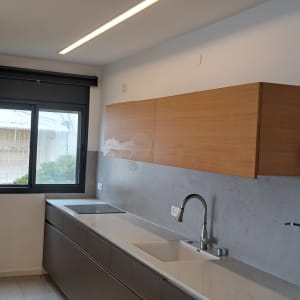 מטבח עם ארונות עץ, כיור וברז מתכת