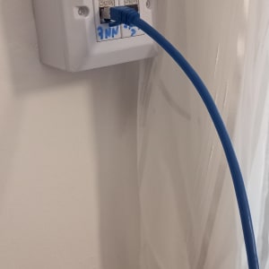 שקע רשת עם כבל כחול מחובר לקיר