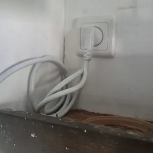 תקע חשמלי לבן מחובר לשקע בקיר