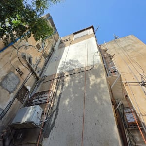 עבודות בסנפלינג לתיקון טיח ושיפוץ חזית בניין מגורים