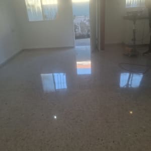 רצפה מבריקה עם מכונת פוליש ואדם בעבודה