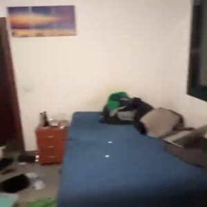 חדר עם מיטה, שידה וחפצים מפוזרים