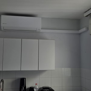 מזגן מותקן במטבח עם ארונות לבנים