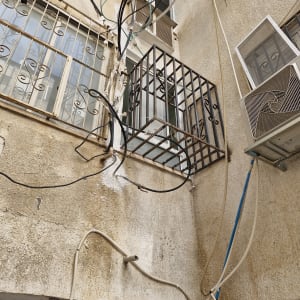 חוטים וצינורות מחוץ לבניין עם מזגנים