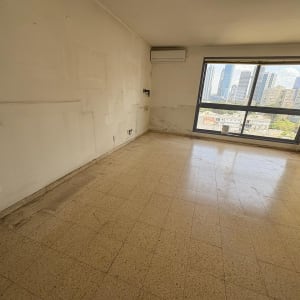 חדר ריק עם חלון גדול ונוף עירוני