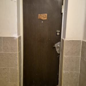 דלת עץ כהה עם שלט ומתחת שטיחון