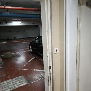 דלת צבועה בחניון עם רכב ברקע