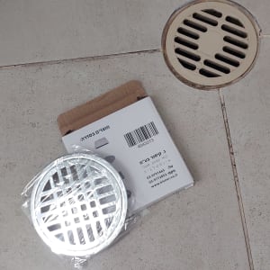 רשת ניקוז עגולה על רצפת אריחים