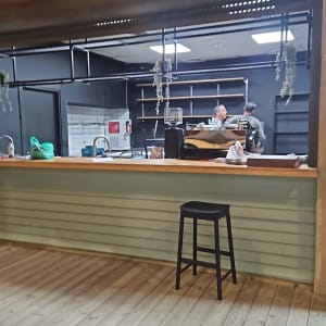 דלפק עץ עם מסגרת מתכת ושני אנשים מאחוריו