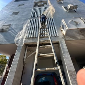אדם על סולם מתקין רשת על בניין