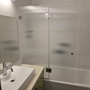 אמבטיון זכוכית פסים עם צירי כרום המותקן על גבי אמבטיה
