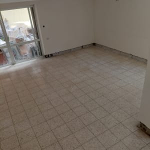 חדר ריק עם רצפת אריחים וקירות לבנים