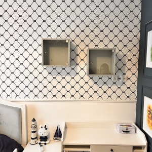 שני ארונות תלויים על קיר עם טפט מעוינים