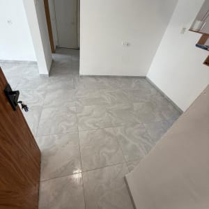 רצפה חדשה עם אריחים אפורים בדירה ריקה