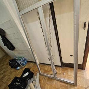 חלקי תריסים וכלים על רצפה ליד דלת