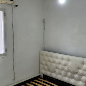 חדר עם קירות צבועים בלבן ונורה תלויה