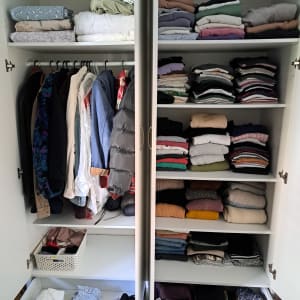 ארון בגדים מסודר עם בגדים מקופלים ותלויים