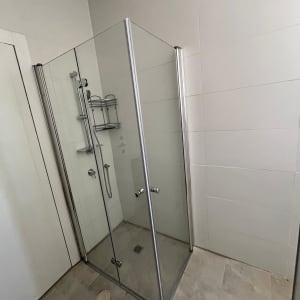 מקלחון זכוכית עם מדף מתכת ומקלחת יד