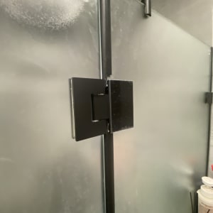 דלת זכוכית למקלחת עם צירים שחורים