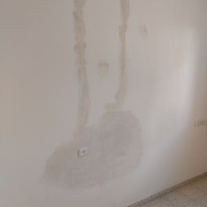 קיר עם תיקוני טיח וצביעה חלקית