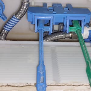 צינורות פלסטיק כחולים וירוקים בתוך קופסת חיבורים