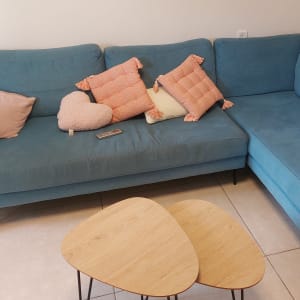 ספה כחולה עם כריות צבעוניות ושלט על המושב