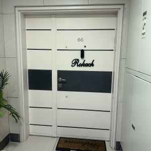 דלת לבנה עם פסים שחורים ושלט "רוקח"