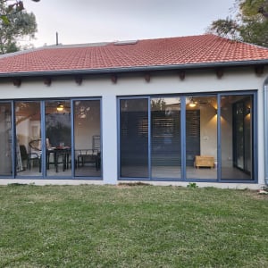 חלונות אלומיניום גדולים בבית עם גג רעפים אדום