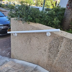 מעקה לבן מותקן על קיר חיצוני