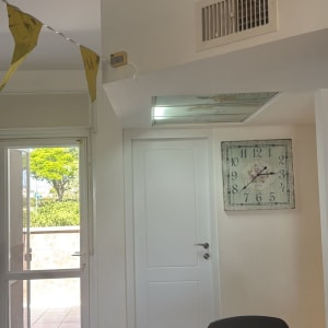 חדר עם דלת לבנה, שעון וקישוטים