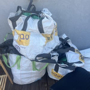 שקי אריזה על רצפת עץ ליד קיר אפור