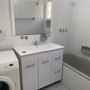 חדר אמבטיה עם כיור, מראה ומכונת כביסה