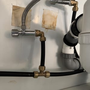 צינורות מתכת ופלסטיק עם מחברים מתחת לכיור