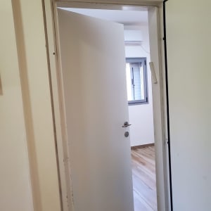 דלת לבנה פתוחה למחצה עם ידית מתכת