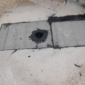 איטום גג עם זפת שחורה סביב חור ניקוז