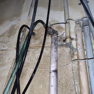 צינורות מתכת וחוטים על קיר חיצוני