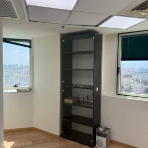 ארון זכוכית בחדר עם רצפת עץ וחלונות
