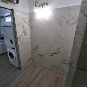 חדר אמבטיה עם אריחים חדשים ומכונת כביסה