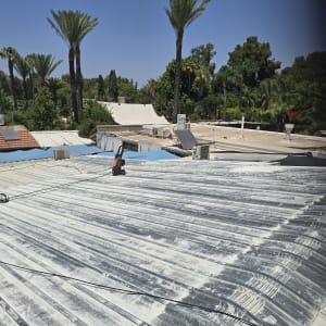 גג מתכת עם עצים ברקע ואדם על הגג