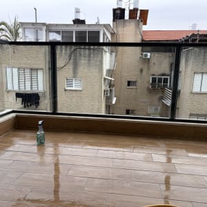 מרפסת נקייה עם בקבוק חומר ניקוי על הרצפה