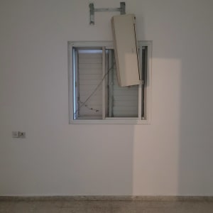 קיר לבן עם מזגן תלוי ליד חלון